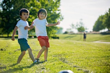 Birlikte futbol oynayan iki sevimli küçük çocuk, yaz. Çocuklar futbol açık oyun