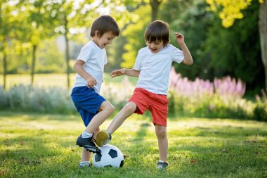 Birlikte futbol oynayan iki sevimli küçük çocuk, yaz. Çocuklar futbol açık oyun
