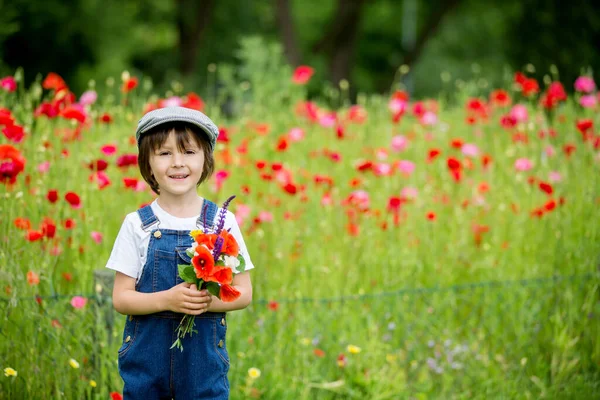 Niedliche Vorschulkind Mohnfeld Hält Einen Strauß Wilder Blumen Lächelt — Stockfoto