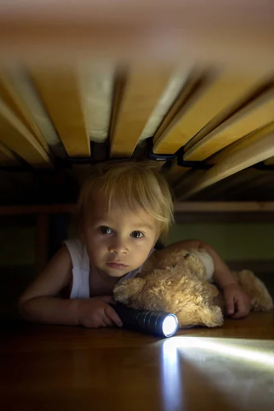 Niño Pequeño Escondido Debajo Cama Abrazando Osito Peluche Sosteniendo Linterna — Foto de Stock