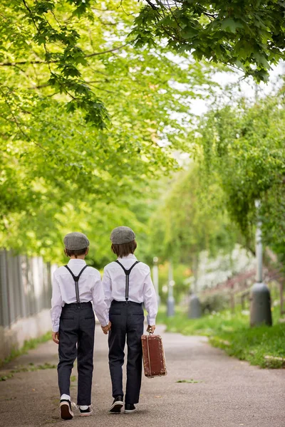 ヴィンテージ服 サスペンダー 白いシャツを着た甘い子供たち スーツケースを持ち 公園で走り 休日に行く — ストック写真