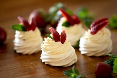 Pavlova Çölü 'nün küçük keki, masasında krema ve çilek olan hafif yumurta ve şeker tatlısı.