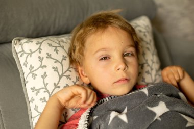 Toddler child with conjuctivitis, lying in bed with red eyes, inflamation of the eye disease, cured with eye drops clipart