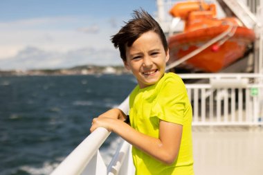 Children, experience ride on a ferry on a fjord, strong wind on the deck of a ferry on a sunny day