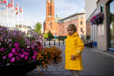 Child, visiting little town in south Norway, Arendal, on a rainy summer day, enjoying splendid views