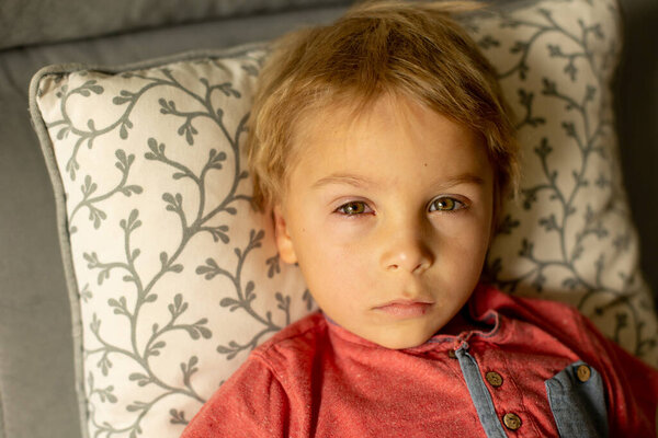 Toddler child with conjuctivitis, lying in bed with red eyes, inflamation of the eye disease, cured with eye drops