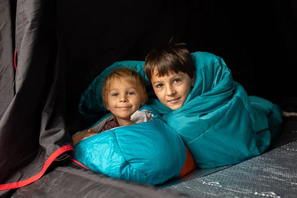 Children, sibilngs, sleeping in sleeping bags in a tent in Norway, wild camping