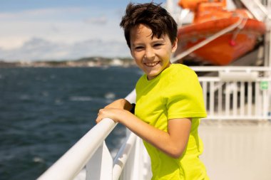 Children, experience ride on a ferry on a fjord, strong wind on the deck of a ferry on a sunny day