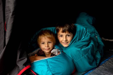 Children, sibilngs, sleeping in sleeping bags in a tent in Norway, wild camping