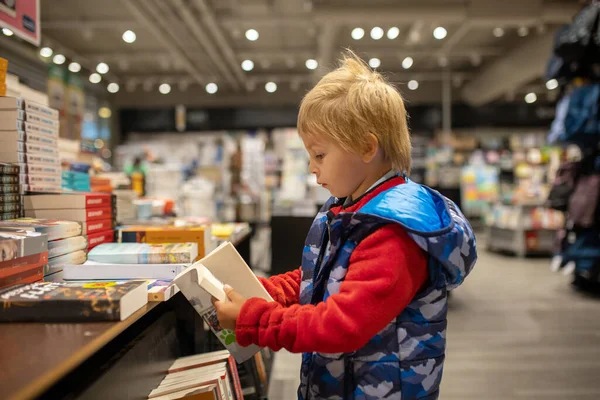 Child, visiting little town in south Norway, Arendal, on a rainy summer day, visiting bookstore