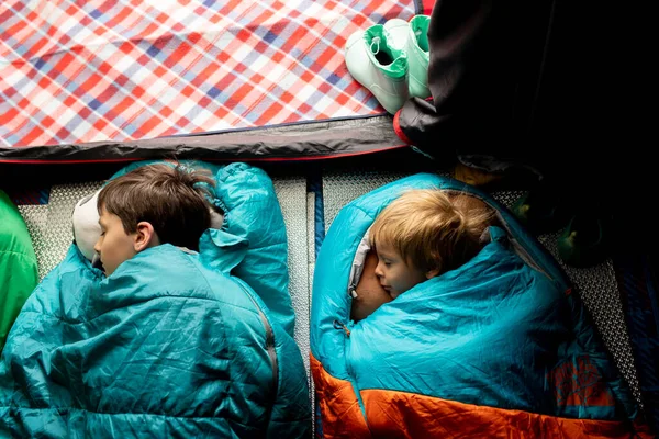 Children, sibilngs, sleeping in sleeping bags in a tent in Norway, wild camping