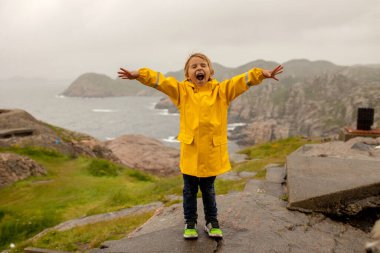 Family with children, visiting the Lindesnes Fyr Lighthouse in Norway on a rainy cold day