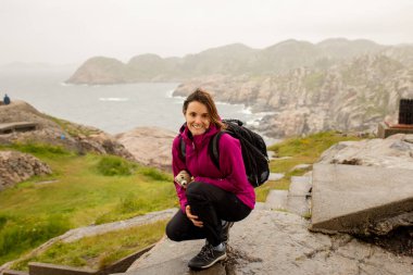 Family with children, visiting the Lindesnes Fyr Lighthouse in Norway on a rainy cold day