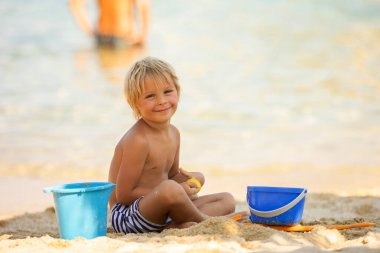 Happy child on the beach, playing in the sand, enjoying summer. Greece, Halkidiki