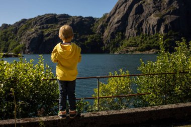 Happy people, enjoying amazing views in South Norway coastline, fjords, lakes, beautiful nature. Kids and adults traveling in Norway summertime