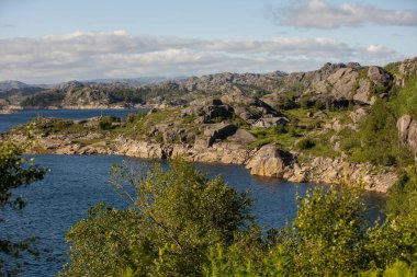 Happy people, enjoying amazing views in South Norway coastline, fjords, lakes, beautiful nature. Kids and adults traveling in Norway summertime