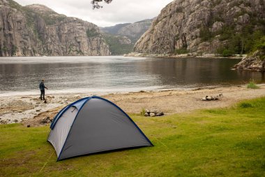 Blue family tent, pitched on the beach in Forsand, Lysebotn on a cloudy day