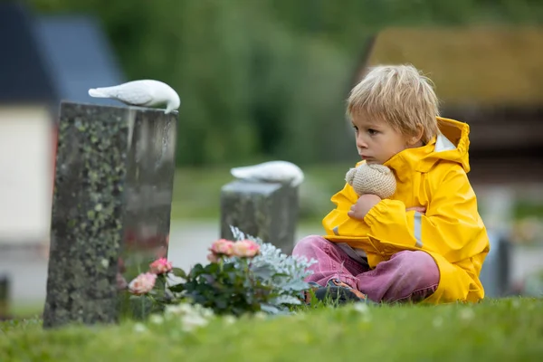 Λυπημένο Μικρό Παιδί Ξανθό Αγόρι Στέκεται Στη Βροχή Στο Νεκροταφείο — Φωτογραφία Αρχείου