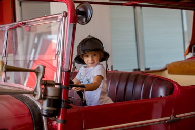 Çocuk, tatlı çocuk, itfaiyeciler gibi giyinmiş itfaiyeciler gibi giyinmiş, çocuklar rüya görüyor.