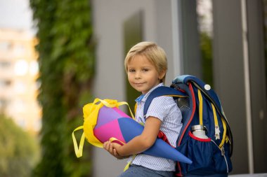 Cute blond child, boy with candy cone on first school day in Czech Republic, old German tradition that what transfer to Czzech as well