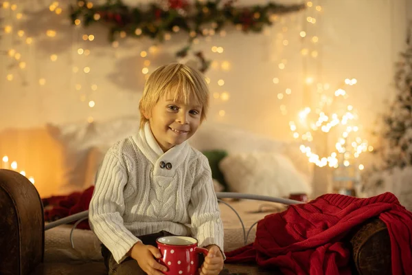 かわいいブロンドの幼児の就学前の男の子 本を読んで 居心地の良い家 ライトと装飾にクリスマスにプレゼント — ストック写真