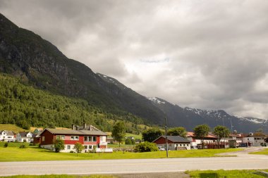 People, adult with kids and pet dog, hiking mount Hoven, enjoying the splendid view over Nordfjord from the Loen skylift