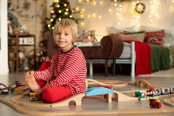 Pijamalı Tatlı Sarışın Çocuk Noel Günü Evde Tren Demiryollarıyla Oynuyor — Stok fotoğraf