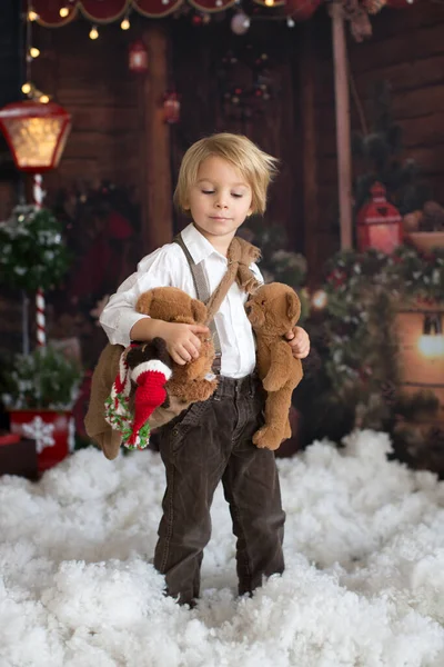 可爱的小屁孩 和玩具熊一起在雪地里玩 在木屋的木柴前 圣诞节的装饰 — 图库照片