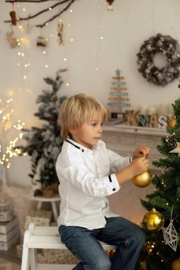 Sevimli çocuk, oğlum, Noel için süslü bir odada oynuyor, rahat bir yerde.