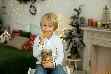 Sevimli çocuk, oğlum, Noel için süslü bir odada oynuyor, rahat bir yerde.