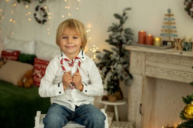 Sevimli çocuk, oğlum, Noel için süslü bir odada oynuyor, rahat bir yerde.