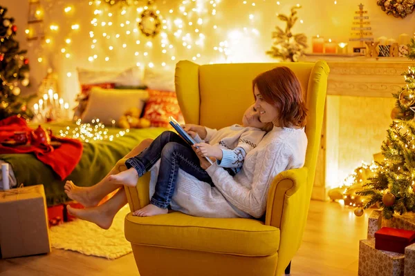 かわいい子供 男の子 クリスマスの装飾された部屋の黄色のアームチェアに座って 居心地の良い場所 — ストック写真