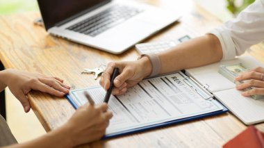 Konut kiralama formunu dolduran yeni ev sahibinin yakın plan resmi, kontrat imzalanması, emlak konsepti