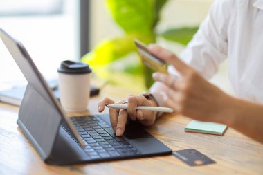 Yakın plan, taşınabilir tablet kullanarak para, kredi kartı ya da kartvizit taşıyan son sınıf öğrencisi.