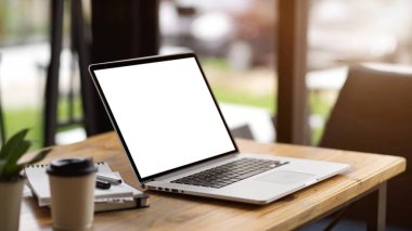 Yakın plan, dijital dizüstü bilgisayarı boş ekran modeli ve ahşap masadaki ofis malzemeleri olan modern ofis.