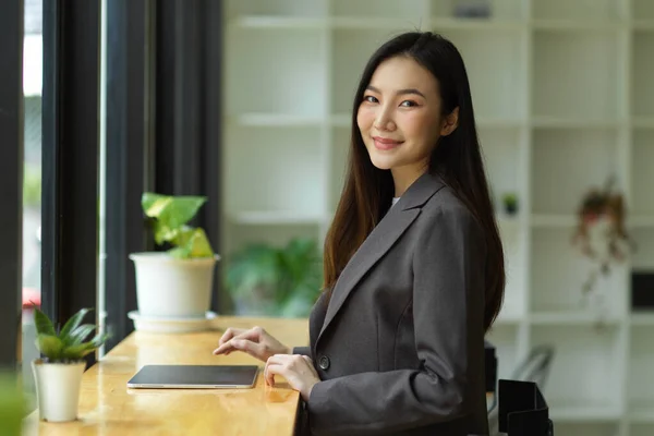 身穿正装的优雅的年轻亚洲女商人带着手提电脑坐在咖啡店里 — 图库照片