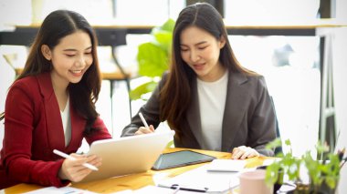 Güzel Asyalı iş kadını ofisteki iş arkadaşlarına iş tavsiyesi veriyor. Yeni proje için takım çalışması, iş arkadaşı toplantısı.