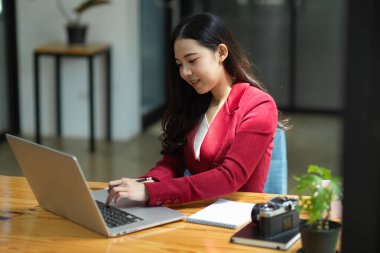 İş yerinde dizüstü bilgisayarı üzerinde çalışan profesyonel bir iş kadını.