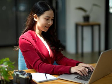 Dizüstü bilgisayarda çalışan Asyalı başarılı iş kadınının resmi portresi. İnternet üzerinden Webinar toplantısında.