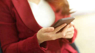 Ofisinde modern akıllı cep telefonu kullanan başarılı iş girişimcisine yakın çekim.