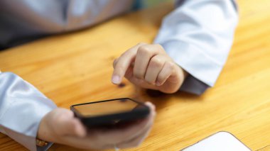 Yetişkin bir kadın modern akıllı cep telefonunu kullanarak internetten alışveriş yapıyor, yemek sipariş ediyor, para transfer ediyor..