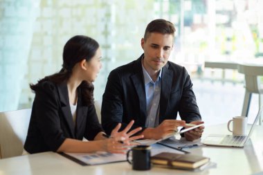 İki iş ortağı modern ofisin gelecekteki planları hakkında konuşuyor.