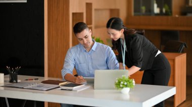 Asyalı kadın patron, yeni beyaz erkek çalışanını çalıştırıyor. İş insanları kavramı