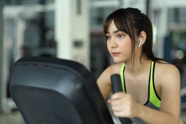 Spor salonunda spor bisikletli Asyalı bir kadının bisiklet sürüşü. egzersiz ve spor.