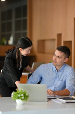 Kadın patron eğitimi ve açıklama beyaz tenli yeni çalışanına yapılır. İş kadını ve işadamı birlikte çalışıyorlar..