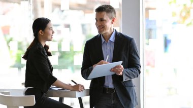 İşadamı proje fikrini yöneticiye, kadın yöneticiye ve çalışanlarına geri bildirim yapan kişiye açıklar..