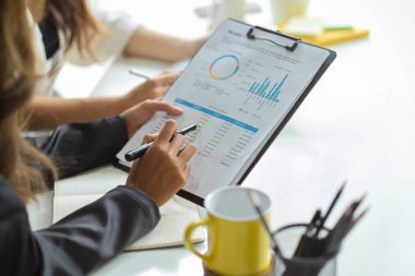 Ofisteki mali raporları inceleyen ve inceleyen kadın finansal danışman imajı.