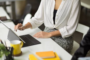 Dijital tablet bilgisayar kullanan, touchpad 'e bir şeyler çizen, ortak çalışma alanında oturan serbest çalışan bir kadın..
