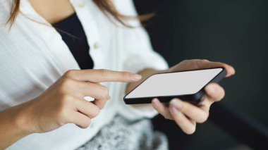 Sosyal medya uygulaması reklamları için boş ekranlı modern akıllı telefon kullanan bir kadın. mobil teknoloji uygulamaları.