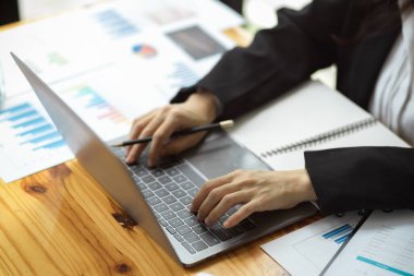 Dizüstü bilgisayar ve finansal veri raporuyla çalışan kadın finans danışmanı. İş adamları iş başında. Yakın çekim, üst görünüm.